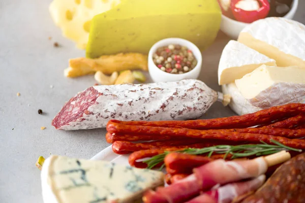 Antipasto tradizionale italiano, tagliere con salame, carne affumicata fredda, prosciutto, prosciutto, formaggi, olive, capperi su fondo grigio. Antipasto di formaggio e carne . — Foto Stock