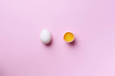 Kırık yumurtalı yemek konsepti ve pembe arka planda bir tane. Üst Manzara. Asgari tarzda yaratıcı bir model. Düz yatıyordu