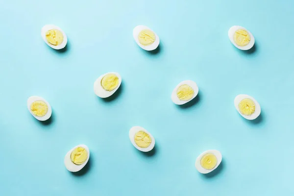 Boiled eggs pattern on blue background. Top view. Creative pattern. Minimal style. Flat lay. Food concept — 스톡 사진