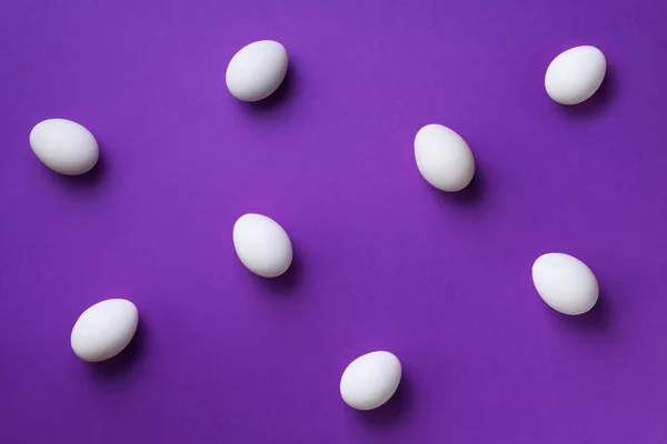 Food concept με λευκά αυγά κοτόπουλου σε βιολετί φόντο. Στο πάνω μέρος. Δημιουργικό μοτίβο σε minimal στυλ. Επίπεδη. — Φωτογραφία Αρχείου