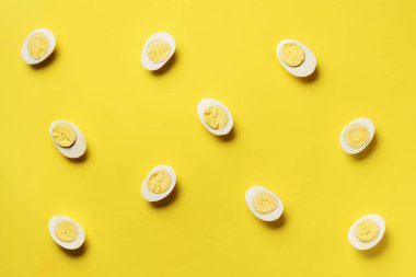 Sarı arka planda haşlanmış yumurta desenli yemek konsepti. Üst Manzara. Asgari tarzda yaratıcı bir model. Düz yatıyordu.