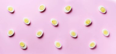 Pembe arka planda haşlanmış yumurta desenli yemek konsepti. Üst Manzara. Asgari tarzda yaratıcı bir model. Düz yatıyordu. Pankart