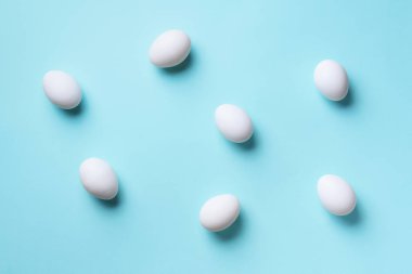 Mavi arka planda beyaz tavuk yumurtası olan yemek konsepti. Üst Manzara. Asgari tarzda yaratıcı bir model. Düz yatıyordu.