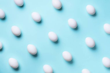 Mavi arka planda beyaz tavuk yumurtası olan yemek konsepti. Üst Manzara. Asgari tarzda yaratıcı bir model. Düz yatıyordu.