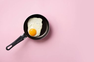 Pembe arka planda tavada pişmiş yumurta ile yaratıcı gıda konsepti. Üst Manzara. Asgari tarzda yaratıcı bir model. Düz yatıyordu.
