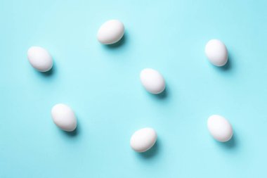 Mavi arka planda beyaz tavuk yumurtası olan yemek konsepti. Üst Manzara. Asgari tarzda yaratıcı bir model. Düz yatıyordu.