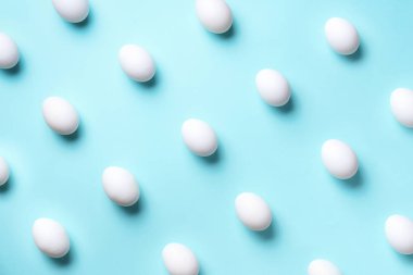 Mavi arka planda beyaz tavuk yumurtası olan yemek konsepti. Üst Manzara. Asgari tarzda yaratıcı bir model. Düz yatıyordu.