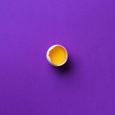Menekşe arka planında beyaz yumurta olan yemek konsepti. Üst Manzara. Asgari tarzda yaratıcı bir model. Düz yatıyordu. Kare mahsul