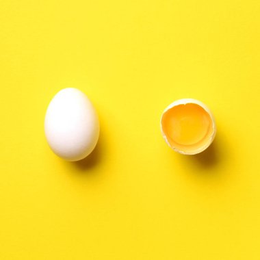 Kırık yumurtalı yemek konsepti ve sarı arka planda bir tane. Üst Manzara. Asgari tarzda yaratıcı bir model. Düz yatıyordu. Kare mahsul