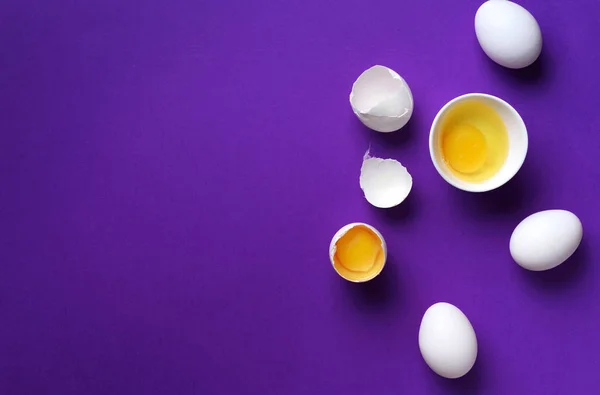 Eggs in white bowl with whisk on violet background. Baking frame — 스톡 사진