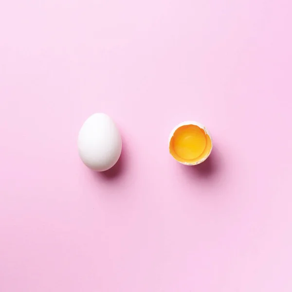 Food concept με σπασμένο αυγό και ολόκληρο σε ροζ φόντο. Στο πάνω μέρος. Δημιουργικό μοτίβο σε minimal στυλ. Επίπεδη. Τετραγωνική καλλιέργεια — Φωτογραφία Αρχείου