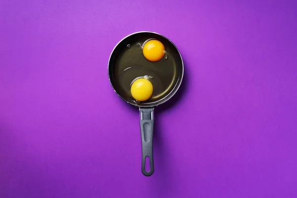 Food concept with two eggs, pan on violet background. Top view. Creative pattern in minimal style. Flat lay. — 스톡 사진