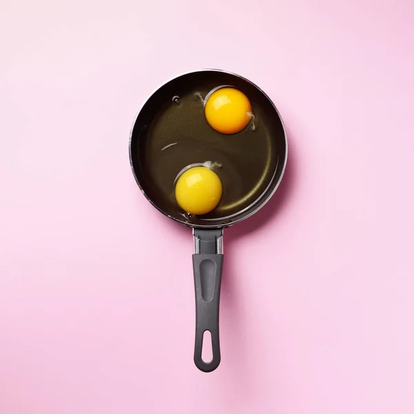 Food concept with two eggs, pan on pink background. Top view. Creative pattern in minimal style. Flat lay. Square crop — 스톡 사진
