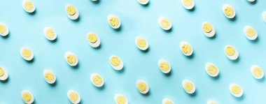 Mavi arka planda haşlanmış yumurta desenli yemek konsepti. Üst Manzara. Asgari tarzda yaratıcı bir model. Düz yatıyordu. Pankart