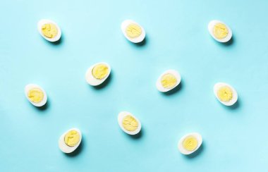 Mavi arka planda haşlanmış yumurta deseni. Üst Manzara. Yaratıcı model. Asgari düzeyde. Düz yatıyordu. Yiyecek konsepti