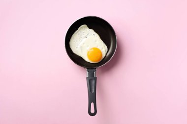 Pembe arka planda tavada pişmiş yumurta ile yaratıcı gıda konsepti. Üst Manzara. Asgari tarzda yaratıcı bir model. Düz yatıyordu.