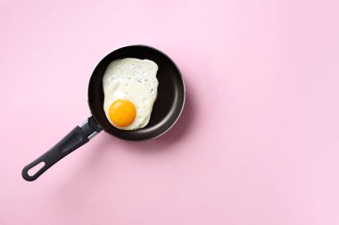 Pembe arka planda tavada pişmiş yumurta ile yaratıcı gıda konsepti. Üst Manzara. Asgari tarzda yaratıcı bir model. Düz yatıyordu.