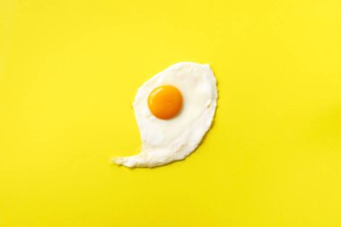 Sarı kağıtta bir sahanda yumurta. Yaratıcı gıda konsepti asgari düzeyde. Üst görünüm
