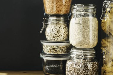 Cam kaplarda beyaz ve kahverengi organik kinoalar. Sağlıklı yemek, temiz yemek, sıfır atık konsepti. Dengeli diyet yemekleri. Boşluğu kopyala.