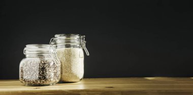 Cam kaplarda beyaz ve kahverengi organik kinoalar. Sağlıklı yemek, temiz yemek, sıfır atık konsepti. Dengeli diyet yemekleri. Uzayı kopyala Kopyalama alanı olan pankart