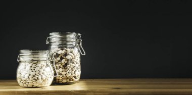 Çeşitli böbrek fasulyeleri. Cam kaplarda kırmızı, beyaz ve siyah fasulye. Sağlıklı yemek, temiz yemek, sıfır atık konsepti. Dengeli diyet yemekleri. Boşluğu kopyala.