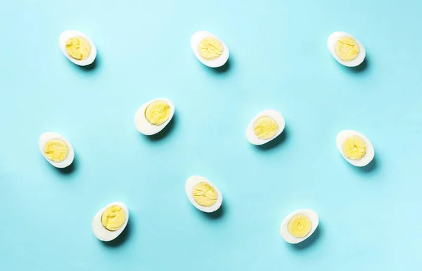 Βραστά αυγά σε μπλε φόντο. Στο πάνω μέρος. Δημιουργικό μοτίβο. Ελάχιστο στυλ. Επίπεδη. Έννοια τροφίμων — Φωτογραφία Αρχείου