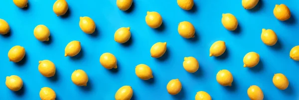 Food pattern with lemons on blue paper background. Top view. Summer concept. Vegan and vegetarian diet. Banner — 스톡 사진