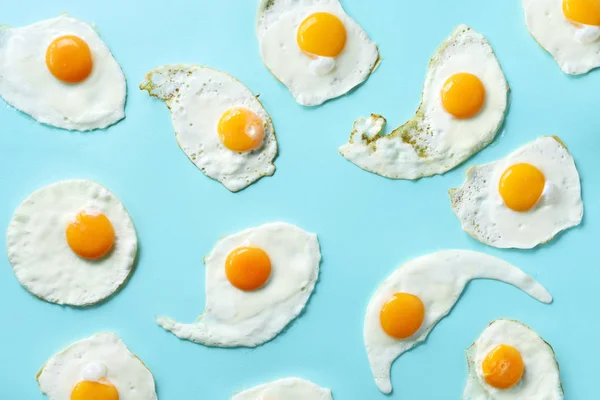 Ovos fritos ou ovos mexidos padrão em fundo azul. Conceito de comida criativa. Vista superior . — Fotografia de Stock