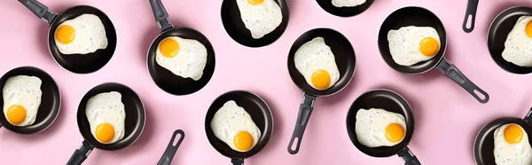 Kreatywny wzór żywności ze smażonymi jajkami na patelniach na różowym tle. Widok góry. Kreatywny wzór w minimalnym stylu. Leżeć płasko. Sztandar — Zdjęcie stockowe