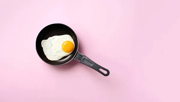 Creative food concept with fried egg on pan over pink background. Top view. Creative pattern in minimal style. Flat lay. — Stock Photo, Image