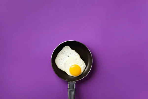 Conceito de comida criativa com ovo frito na panela sobre fundo violeta. Vista superior. Padrão criativo em estilo mínimo. Depósito plano — Fotografia de Stock