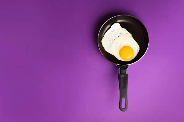 Creative food concept with fried egg on pan over blue background. Top view. Creative pattern in minimal style. Flat lay