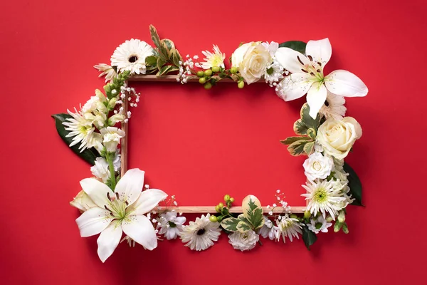 Bloemen frame van witte bloemen, groene bladeren op rood papier achtergrond. Vlakke lay, bovenaanzicht. Voorjaars- en zomerconcept — Stockfoto