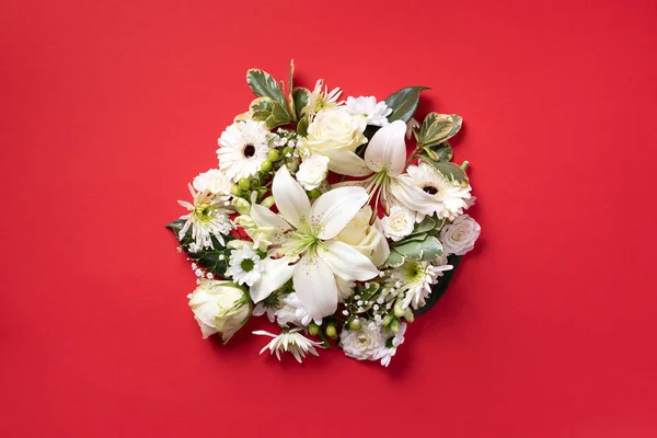 Bloemen samenstelling van witte bloemen, groene bladeren op rood papier achtergrond. Vlakke lay, bovenaanzicht. Voorjaars- en zomerconcept — Stockfoto