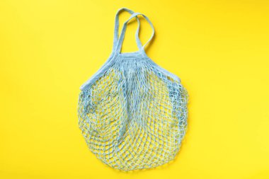 Yeniden kullanılabilir ağ torbası ya da sarı kağıttan alışveriş yapan kişi. Sıfır atık, plastiksiz konsept. Üst Manzara. Çevre dostu yeniden kullanılabilir ağ alıcısı. Kopyalama alanı olan pankart