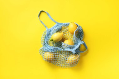 Sarı kağıtta limonlu alışveriş torbası. Düz yerde, üst tarafta. Sıfır atık, plastiksiz konsept. Sağlıklı beslenme ve detoks. Yaz meyveleri