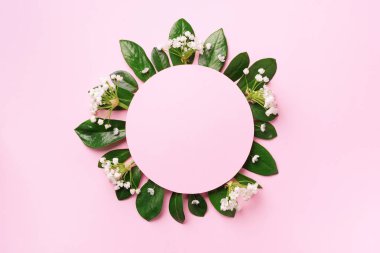 Yeşil tropikal yapraklardan ve pembe arka planda beyaz çiçeklerden oluşan yaratıcı bir düzen. Üst Manzara. Düz yatıyordu. Yaz ya da bahar doğa konsepti. Reklam kartı ya da davetiye için boş. Model