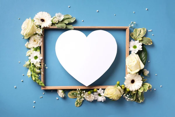 Marco de flores blancas, corazón de papel sobre fondo azul. Día de San Valentín, concepto del día de la mujer. Banner de primavera o verano con espacio para copiar — Foto de Stock