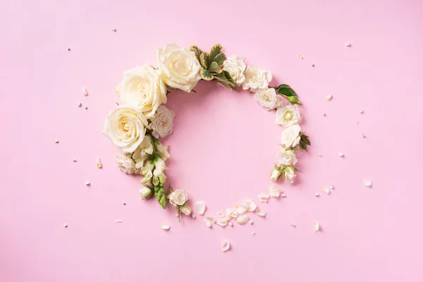 Bloemen samenstelling. Toorn gemaakt van witte rozen en rozenblaadjes op een roze achtergrond. Vlakke lay, bovenaanzicht. Banner met kopieerruimte — Stockfoto