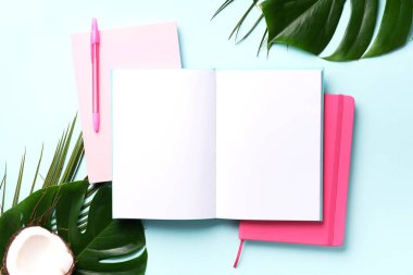 Kadın blog yazarı çalışma alanı kavramı. Yeşil canavar palmiye yaprakları, pembe arka planda hindistan cevizi ve fotokopi alanı. Pankart. Düz yatış, üst görünüm.