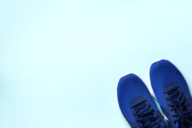 Mavi arka planda bir çift spor ayakkabısı. Üst görünüm, boşluğu kopyala. Spor, spor ve spor konsepti. Sağlıklı yaşam tarzı