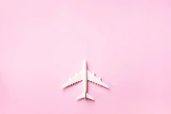 Creative layout. Top view of white model plane, airplane toy on pink pastel background. Flat lay with copy space. Trip or travel banner — 스톡 사진