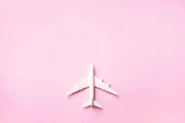 Creative layout. Top view of white model plane, airplane toy on pink pastel background. Flat lay with copy space. Trip or travel banner — Stock Photo, Image