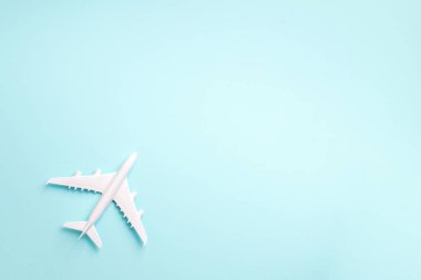 Beyaz uçak, mavi pastel renkli arka planda fotokopi alanı olan uçak. Üst manzara, düz yatış. Asgari tarz tasarım. Seyahat, tatil konsepti