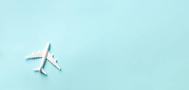 Seyahat, tatil konsepti. Pastel mavi arka planda fotokopi alanı olan beyaz model bir uçak. Üst Manzara. Düz yatıyordu. Asgari tarz tasarım. Pankart