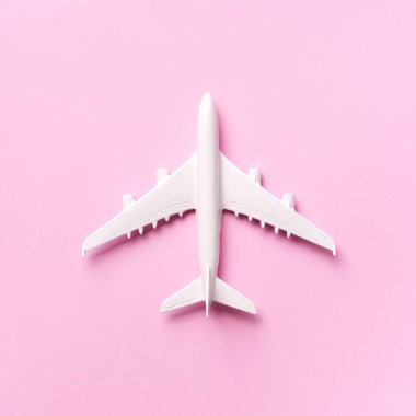 Seyahat, tatil konsepti. Pastel pembe arka planda fotokopi alanı olan beyaz model bir uçak. Üst Manzara. Düz yatıyordu. Asgari tarz tasarım. Kare mahsul