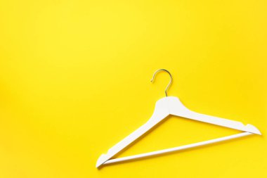 Beyaz elbiseler sarı arka planda asılı ve fotokopi alanı var. Düz yatıyordu. Üst Manzara. Minimalizm tarzı. Yaratıcı düzen. Moda, mağaza satışı, alışveriş konsepti. Kadınsı blog için afiş