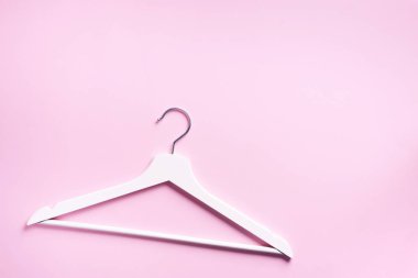 Beyaz elbise askılarının üst görüntüsü pembe arka planda ve fotokopi alanı var. Düz yatıyordu. Minimalizm tarzı. Yaratıcı düzen. Moda, mağaza satışı, alışveriş konsepti. Kadınsı blog için afiş