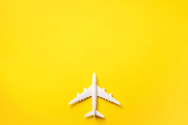 Viagens, conceito de férias. Avião modelo branco em fundo de cor amarela com espaço de cópia. Vista superior. Deitado. Design de estilo mínimo . — Fotografia de Stock