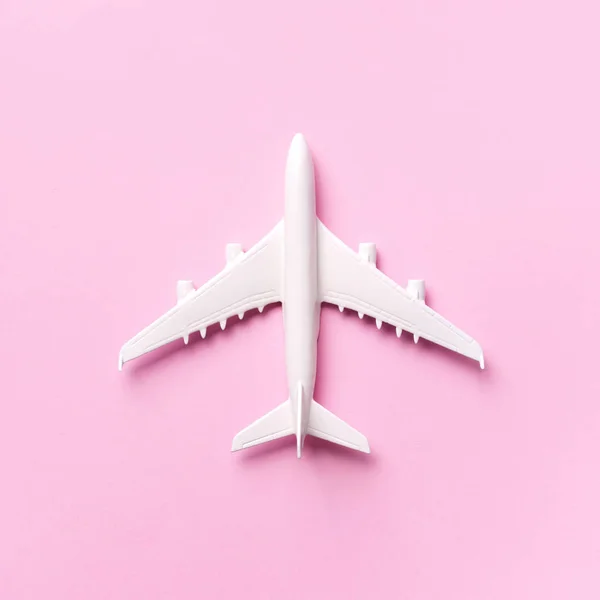 Reizen, vakantie concept. Wit model vliegtuig op pastelroze achtergrond met kopieerruimte. Bovenaanzicht. Plat gelegd. Minimaal ontwerp. Vierkante gewassen — Stockfoto